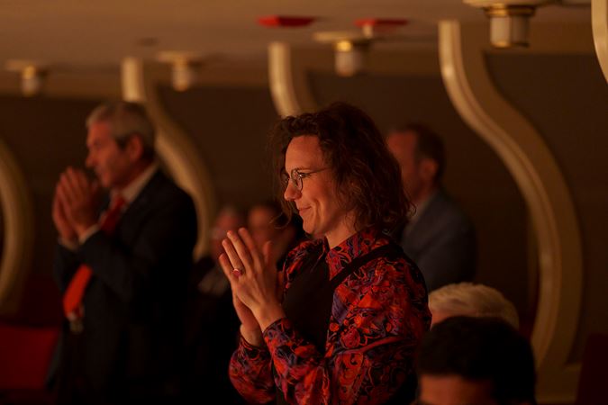 An audience member applauding from the Box Level