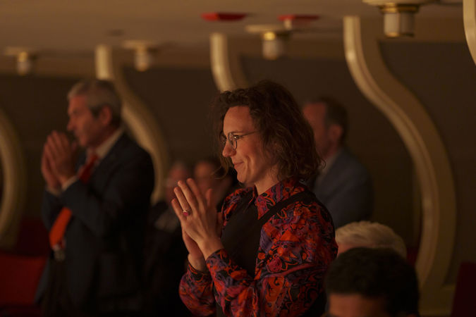 An audience member applauding from the Box Level