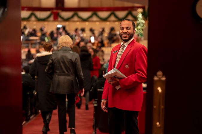 An usher smiling at the entry way of Orchestra Hall