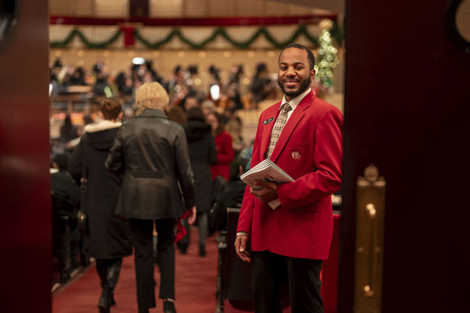An usher smiling at the entry way of Orchestra Hall