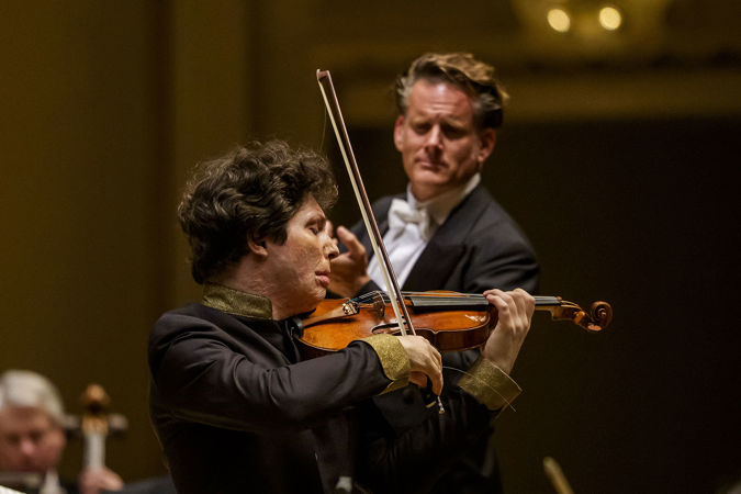 Closeup action shot of violinist Augustin Hadelich on stage